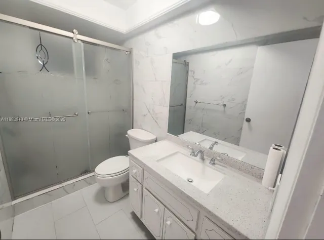 a bathroom with a sink a toilet and a large mirror