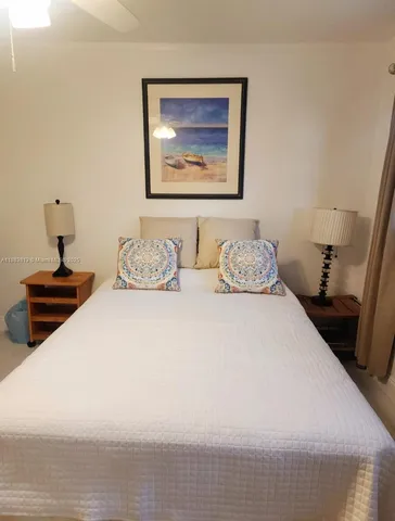 a bedroom with a bed and a lamp on dresser