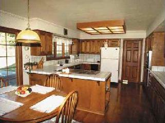3433 Rolling Oaks Road Santa Rosa, CA 95404 - Photo 5 of 11 a kitchen with stainless steel appliances granite countertop a sink a refrigerator a stove a dining table and chairs with wooden floor