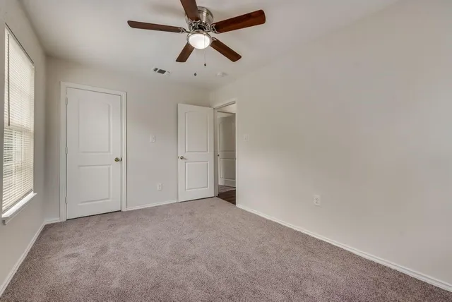 an empty room with chandelier fan