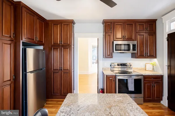 a kitchen with stainless steel appliances granite countertop a refrigerator stove and sink