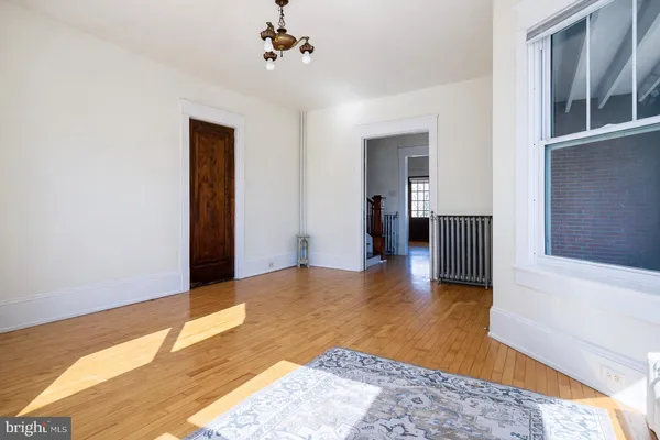 a view of a livingroom with wooden floor and a ceiling fan