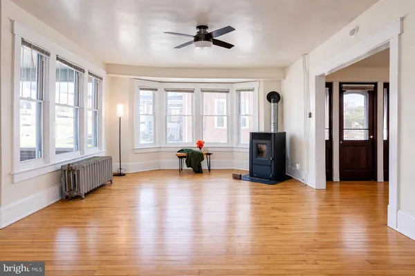 a view of a livingroom with furniture a ceiling fan and hardwood floor