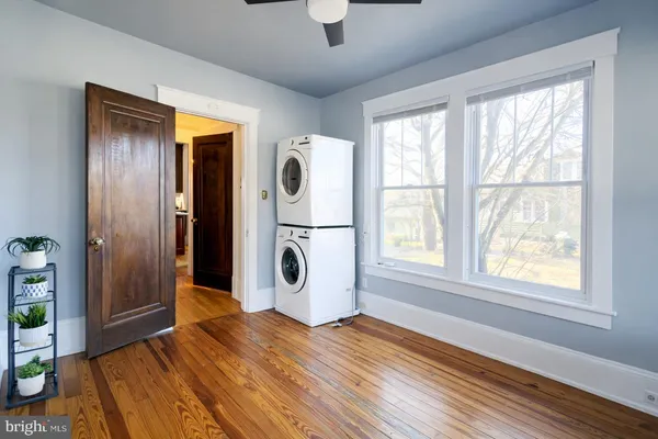 a view of empty room with wooden floor and fan