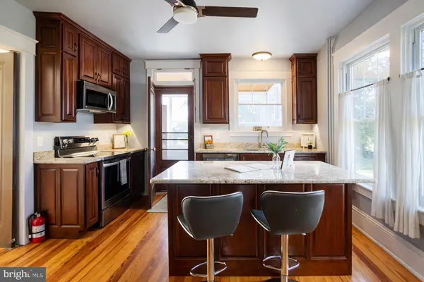 a kitchen with stainless steel appliances granite countertop a stove refrigerator and a sink