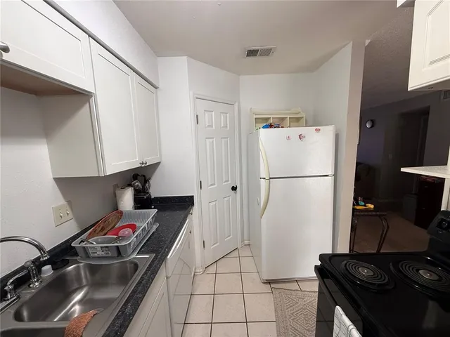 a kitchen with a refrigerator and a stove top oven