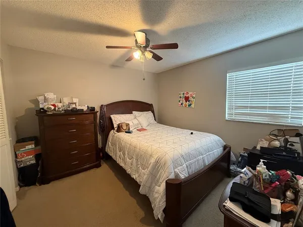 a bedroom with a bed and a ceiling fan