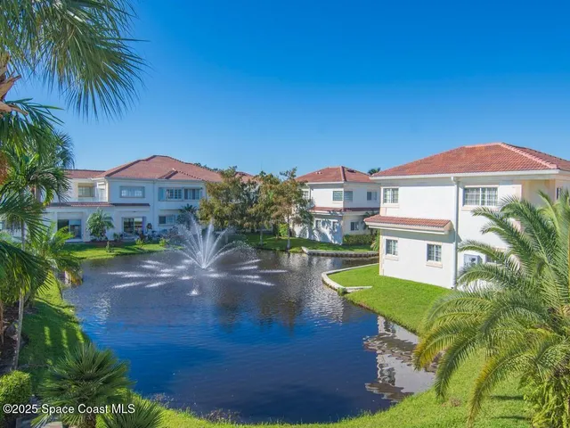 a view of a house with a yard and a pond
