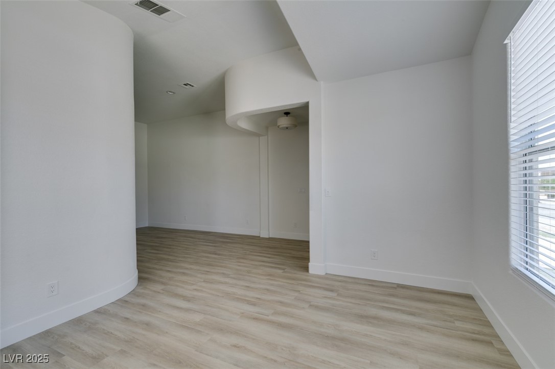823 Wintersweet Road Henderson, NV 89015 - Photo 12 of 50 Spare room with healthy amount of natural light and light wood finished floors