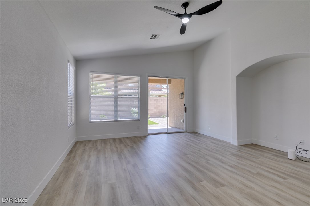 823 Wintersweet Road Henderson, NV 89015 - Photo 19 of 50 Spare room with a ceiling fan, light wood-type flooring, vaulted ceiling, and arched walkways
