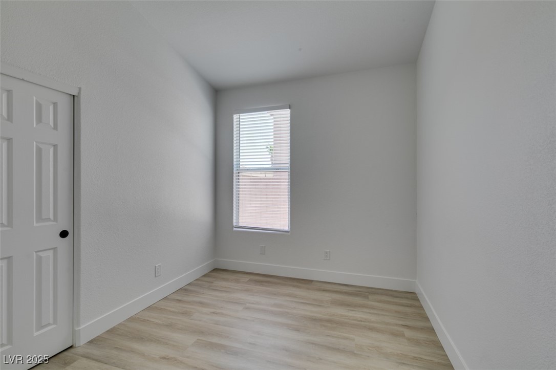 823 Wintersweet Road Henderson, NV 89015 - Photo 34 of 50 Unfurnished bedroom featuring light wood finished floors and baseboards