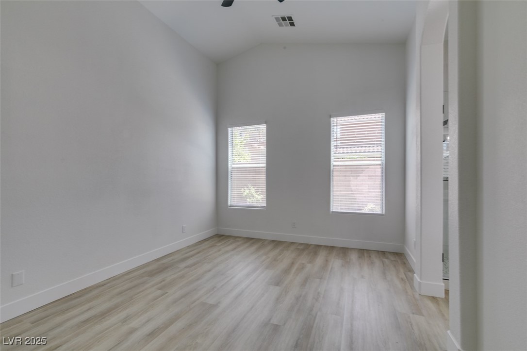 823 Wintersweet Road Henderson, NV 89015 - Photo 37 of 50 Empty room with lofted ceiling, light wood-style flooring, and ceiling fan