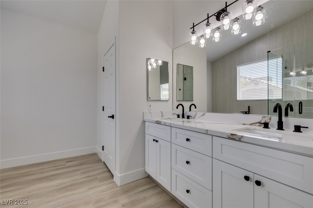 823 Wintersweet Road Henderson, NV 89015 - Photo 41 of 50 Full bath featuring double vanity, a stall shower, light wood-style floors, and vaulted ceiling
