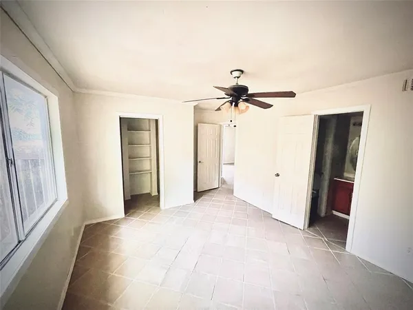 a view of a room with a ceiling fan and window