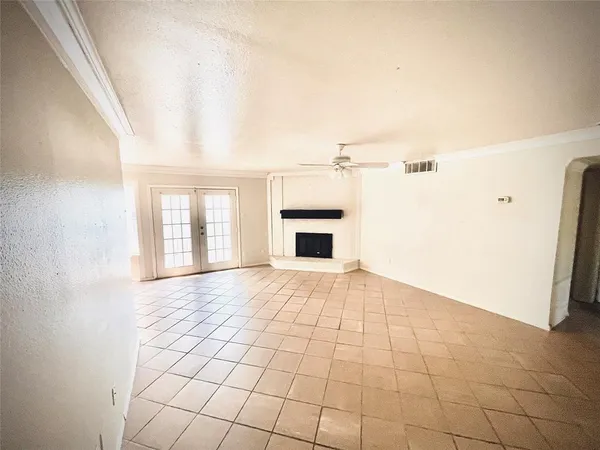 a view of an empty room with a fireplace and a window