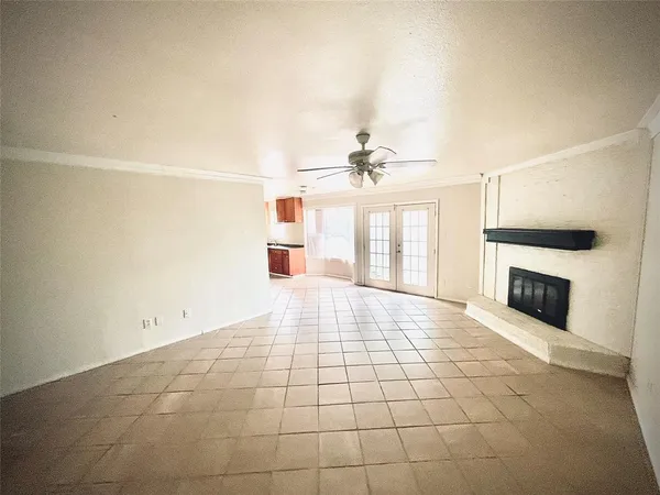 a view of an empty room with a fireplace and a window