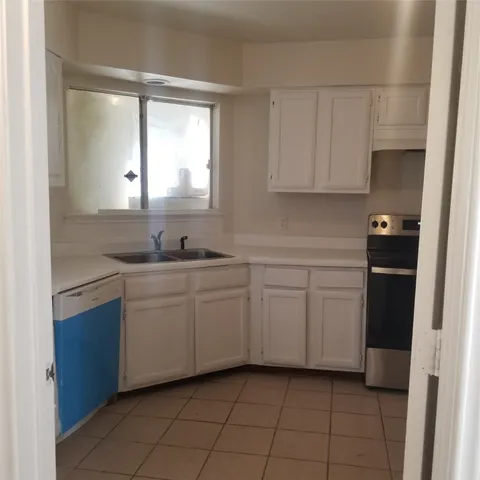 a kitchen with a refrigerator sink and cabinets