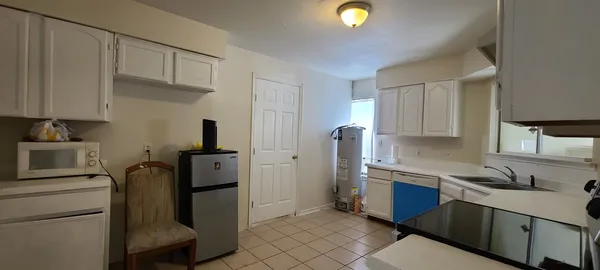 a kitchen with white cabinets and black appliances