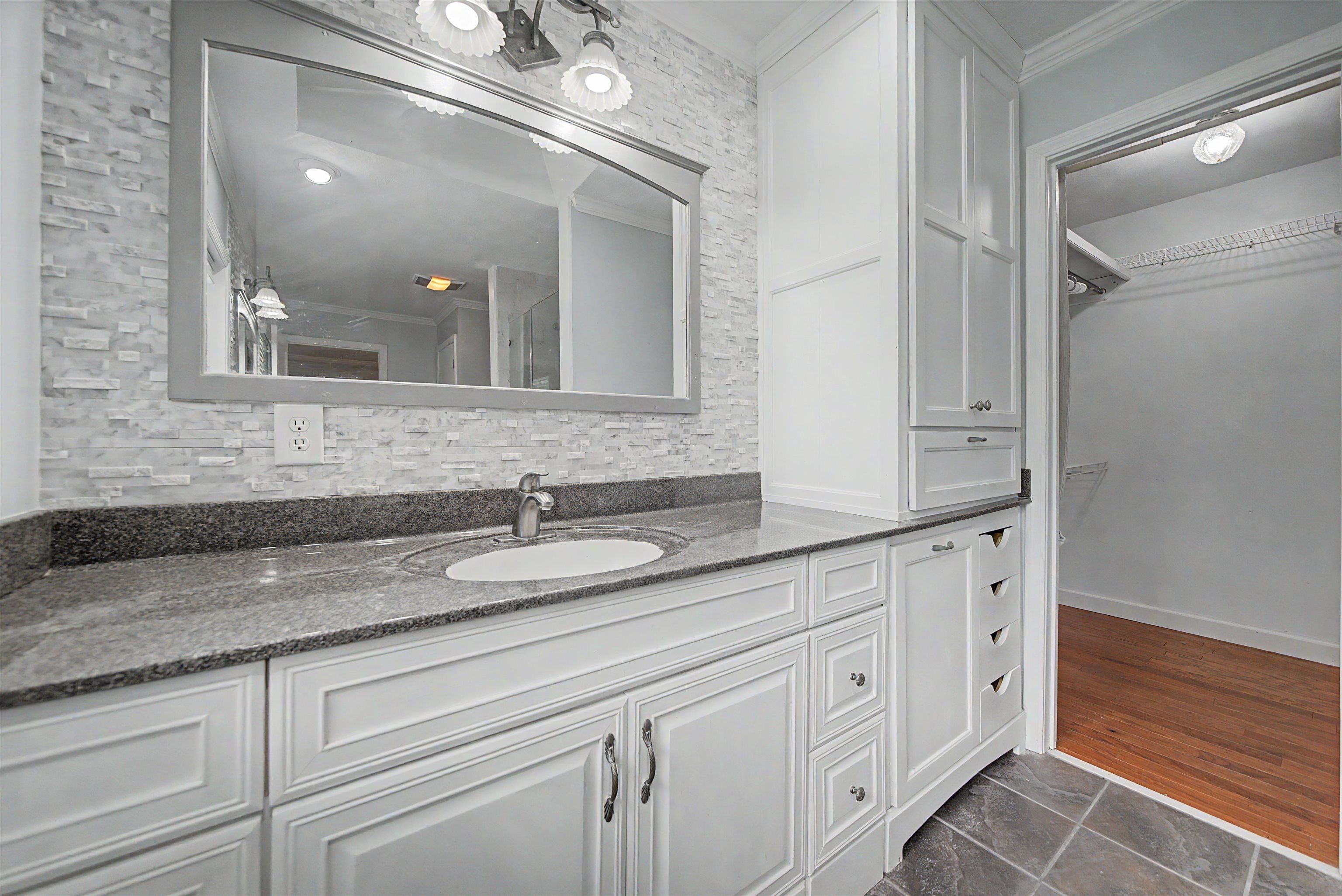 436 Skyline Road Selmer, TN 38375 - Photo 26 of 40 Bathroom vanity with a vessel sink, dark stone countertop, and white shaker-style cabinetry