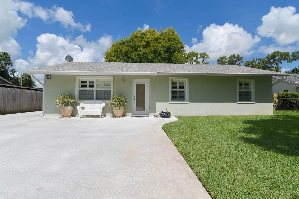5547 3rd Road Lake Worth, FL 33467 - Photo 2 of 34 a front view of a house with a garden and patio