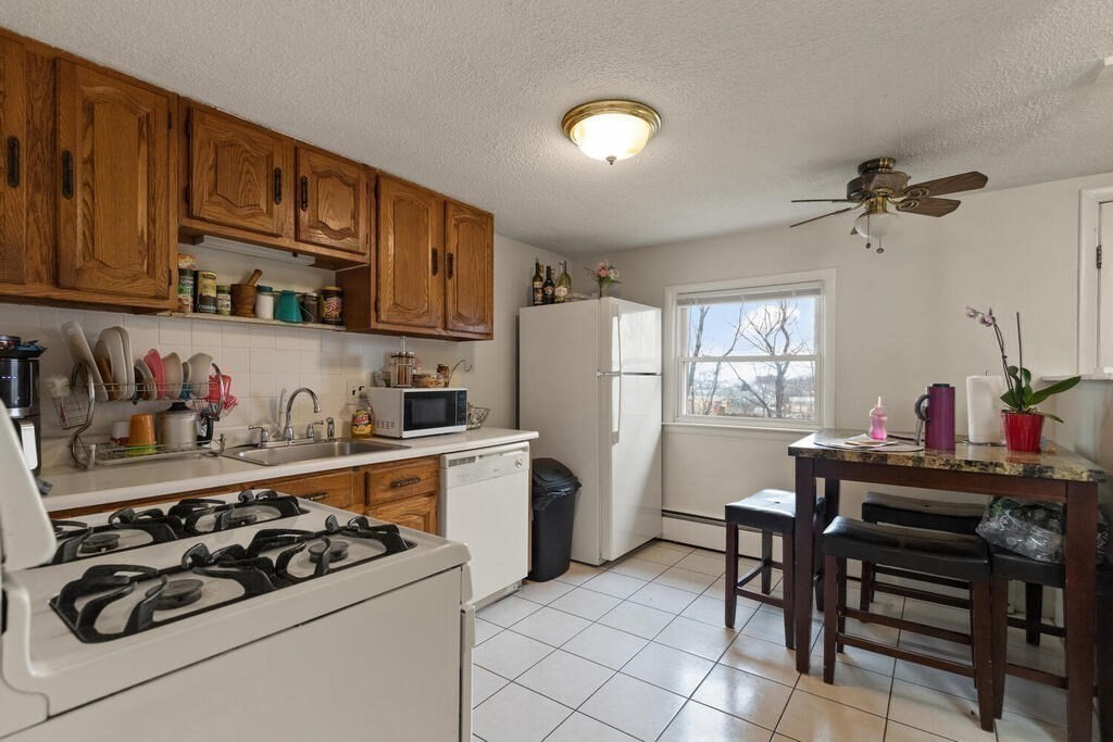 148 Ridge Road Revere, MA 02151 - Photo 25 of 31 a kitchen with a stove and white cabinets
