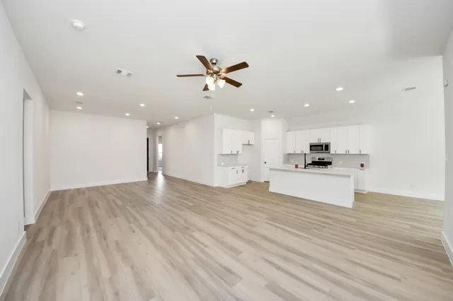 a view of kitchen with kitchen island stainless steel appliances refrigerator stove microwave and cabinets