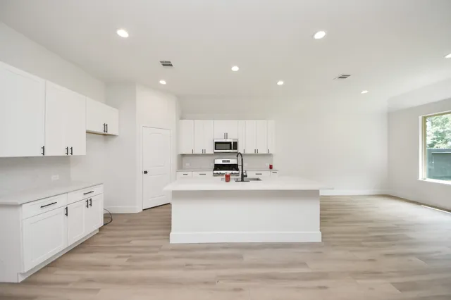 a view living room with stainless steel appliances kitchen island sink and living room