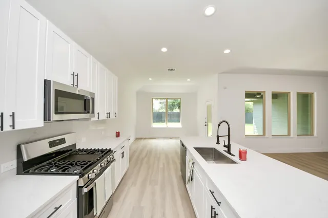 a kitchen with a stove a sink and a microwave