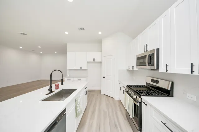 a kitchen with a sink stainless steel appliances and cabinets