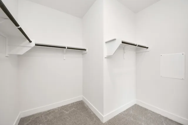 a view of walk in closet with clothes