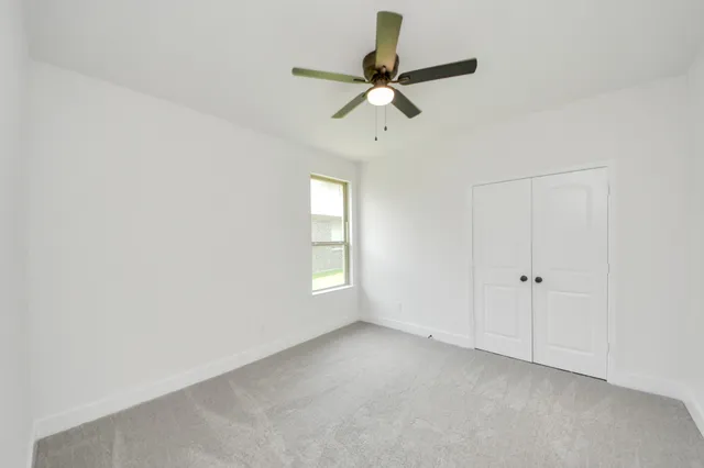a view of a livingroom with a window and a ceiling fan
