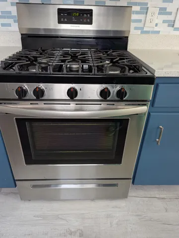a stove top oven sitting inside of a kitchen