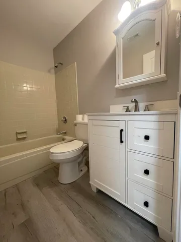 an empty room with wooden floor cabinet and windows
