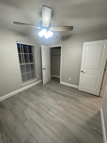 an empty room with wooden floor and white doors