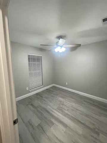 an empty room with a walk in closet and hardwood floor