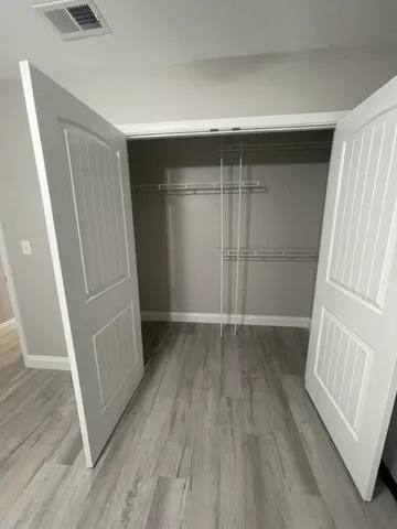 a utility room with granite countertop a sink and cabinets