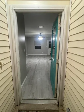 a view of a hallway with wooden floor