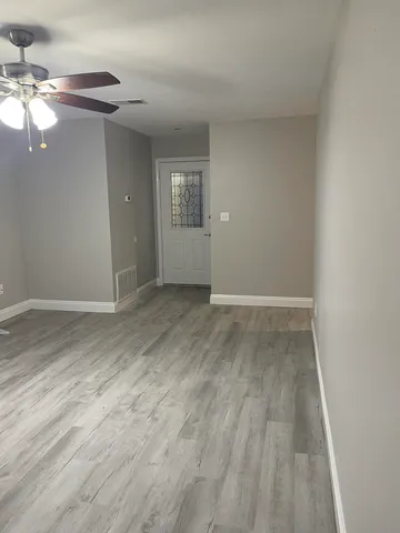 an empty room with wooden floor and windows