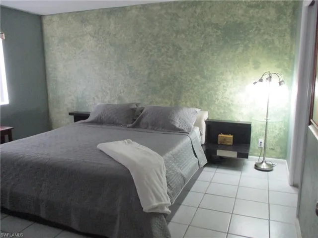 a bedroom with a bed a fireplace and a shower