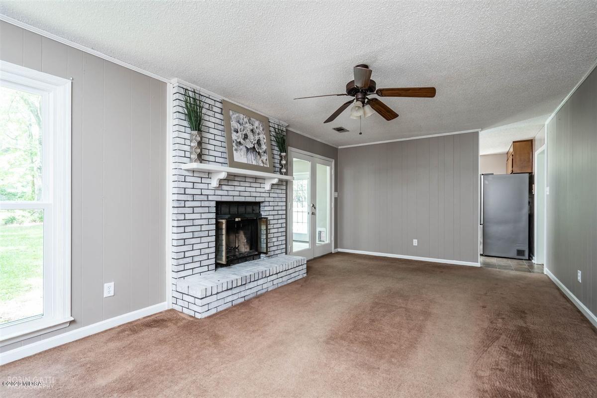 243 Lake Joy Road Perry, GA 31069 - Photo 2 of 29 a view of an empty room with chandelier fan and fire place