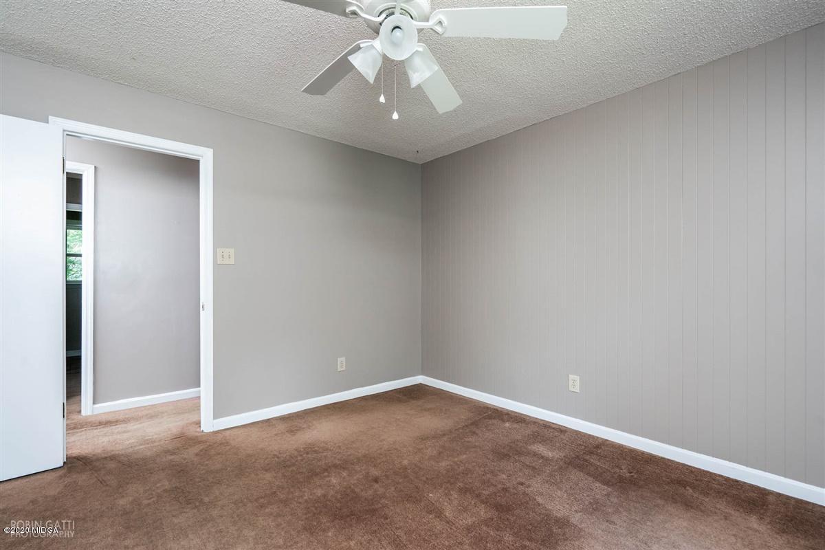 243 Lake Joy Road Perry, GA 31069 - Photo 16 of 29 an empty room with a chandelier fan and windows