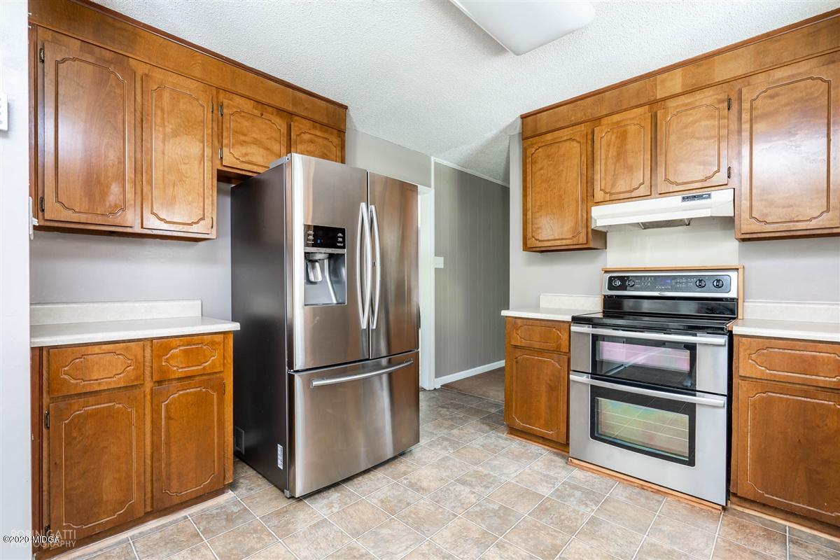 243 Lake Joy Road Perry, GA 31069 - Photo 5 of 29 a kitchen with stainless steel appliances granite countertop a refrigerator stove and cabinets