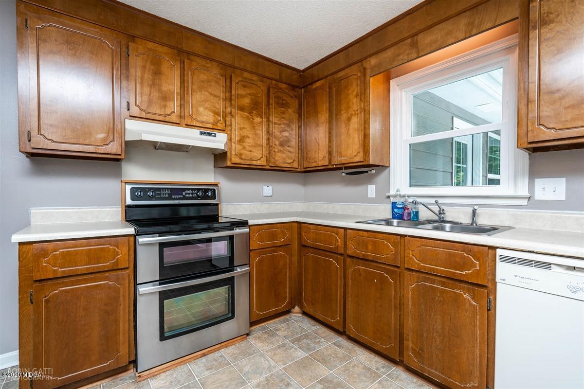 243 Lake Joy Road Perry, GA 31069 - Photo 6 of 29 a kitchen with stainless steel appliances granite countertop a stove a sink and a microwave