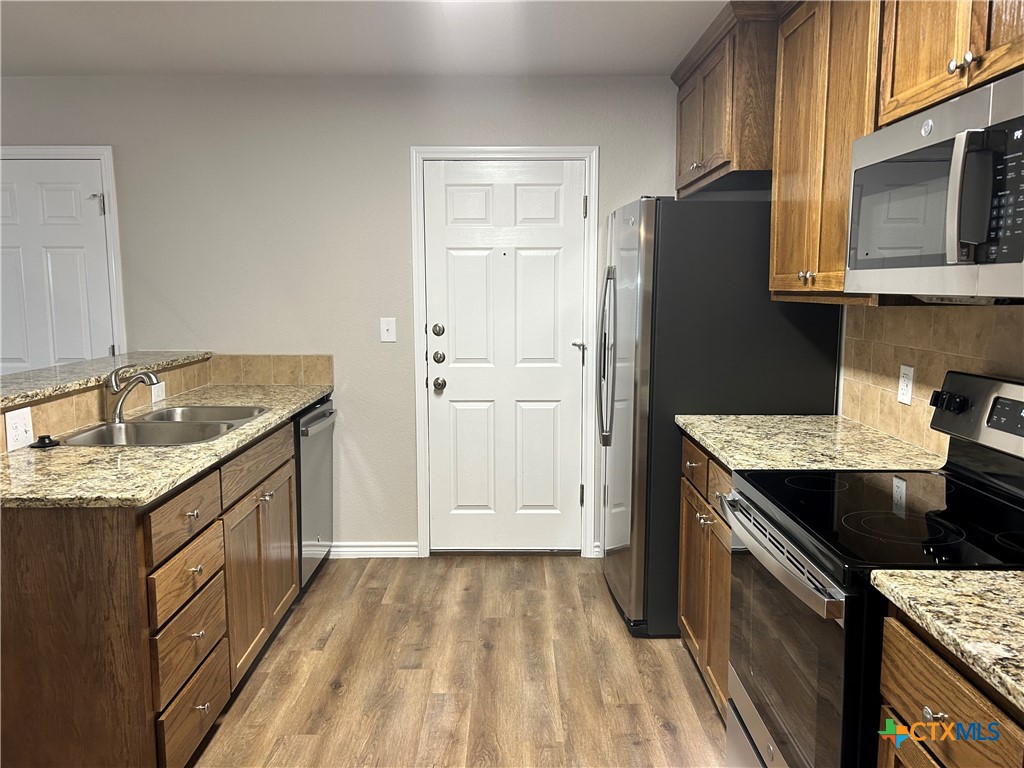 2618 Leroy Lane, Unit B Belton, TX 76513 - Photo 7 of 12 a kitchen with granite countertop a sink stove and refrigerator