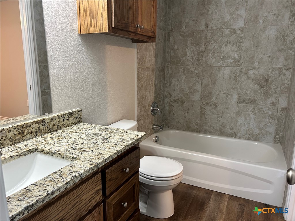 2618 Leroy Lane, Unit B Belton, TX 76513 - Photo 10 of 12 a bathroom with a granite countertop bathtub sink vanity mirror and toilet