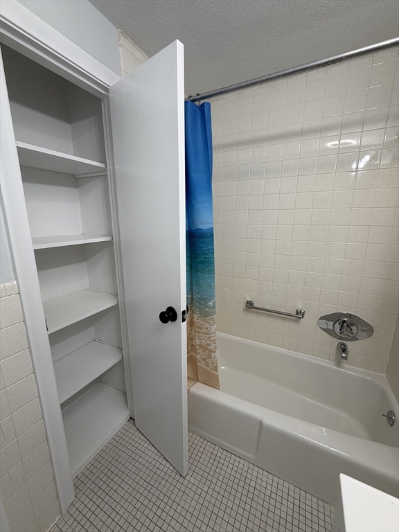 85 Trapelo Road, Unit 40 Waltham, MA 02452 - Photo 8 of 15 a bathroom with a bathtub and a shower