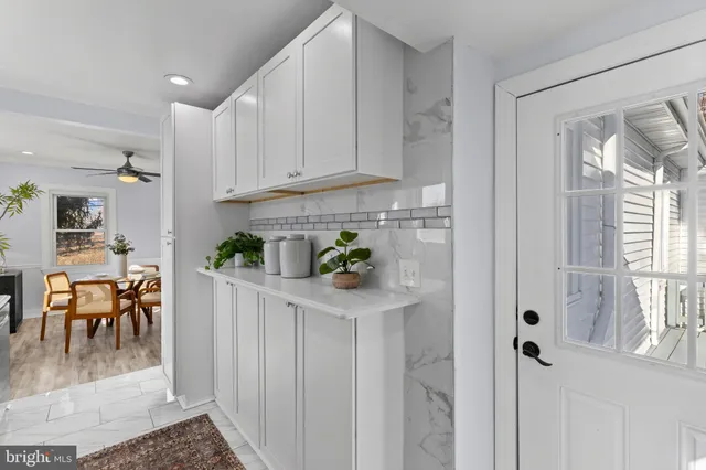 a kitchen with white cabinets and wooden floor