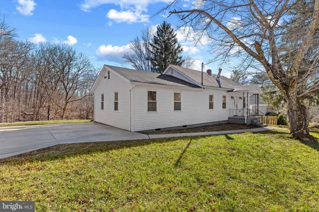 a view of a house with pool and trees in the background