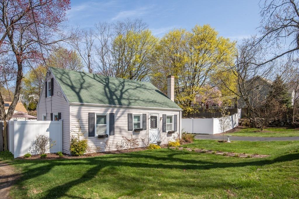 a front view of a house with a garden and trees