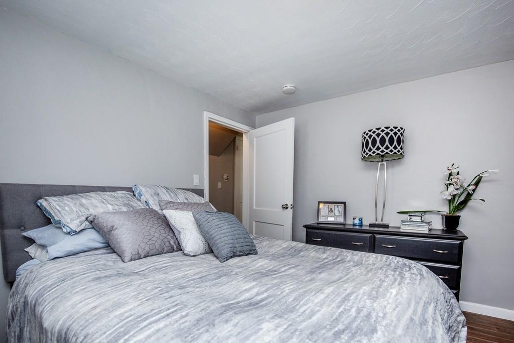 21 Forest Street Peabody, MA 01960 - Photo 14 of 29 a bedroom with a bed and a lamp on dresser